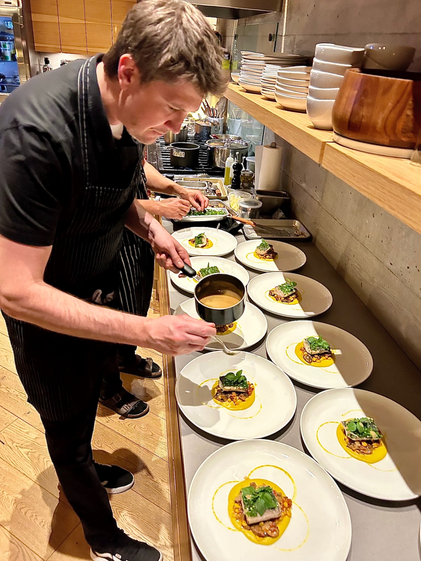 Chef Michaël finishing a plated course in the kitchen