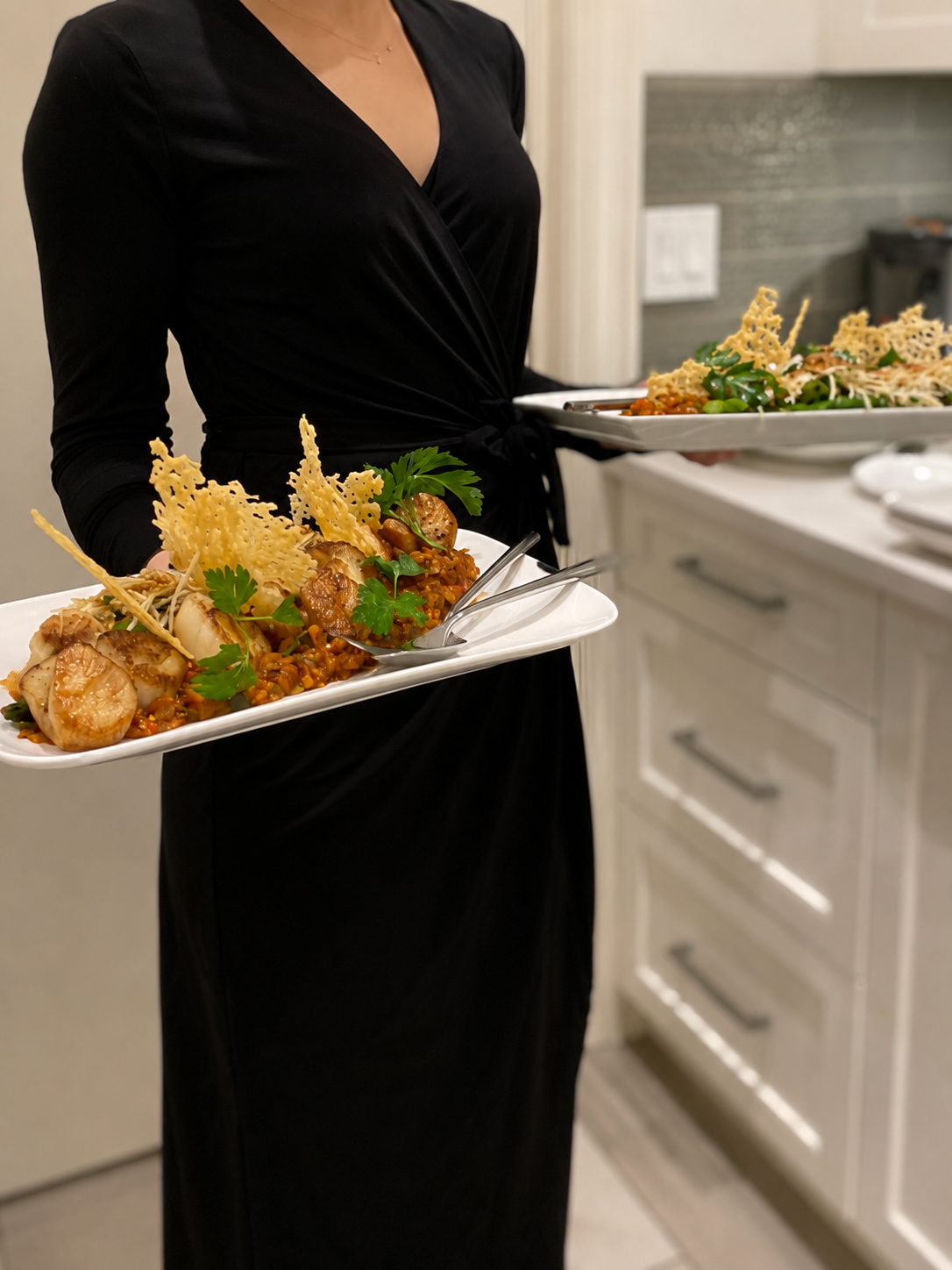 Server carrying a platter of seared scallops with parmesan tuiles
